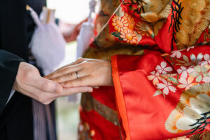 赤色の打掛を着た花嫁と手を重ね合っている富山フォトウェディング