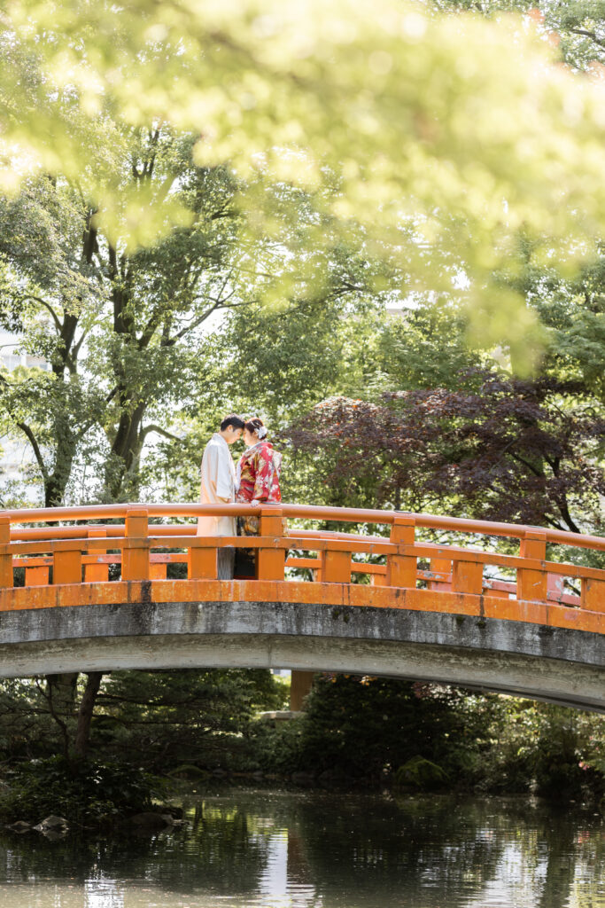 富山城址公園の赤い橋でおでこを合わせる和装新郎新婦のフォトウェディング