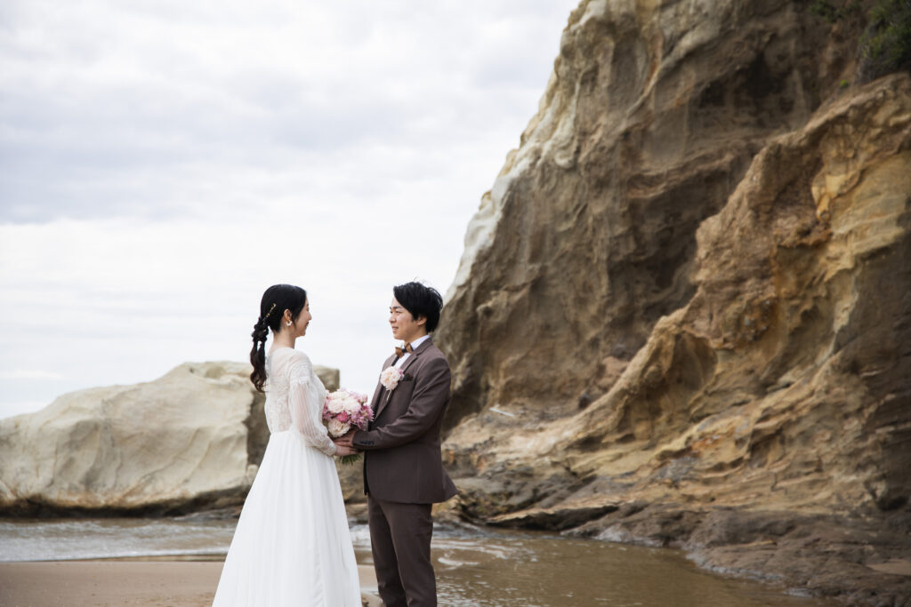 石川県で撮影した崖と海の壮大の景色のフォトウェディング。富山からお越しの洋装新郎新婦