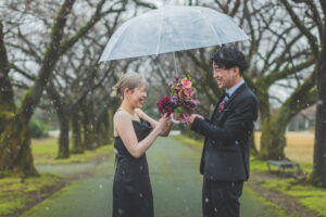 富山の中央植物園で雪の中黒いドレスと黒スーツで撮影をする洋装新郎新婦の前撮りフォトウェディング