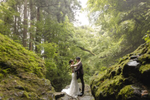 富山の千巖渓で森林の中のロケーションフォトウェディングを行う洋装新郎新婦の写真