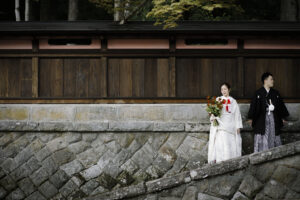 富山の教算坊の石垣の前でかっこよく撮影した和装新郎新婦のロケーションフォトウェディング