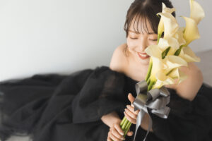 富山のコアラで洋装フォトウェディングを行なった花嫁がブーケを持って目をつぶって笑っている様子