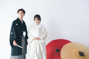 富山のコアラで和装スタジオフォトウェディングを行なった新郎新婦が和傘と共に撮影している