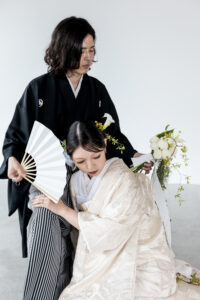 富山のコアラで和装フォトウェディングを行なっている新郎新婦が座ってかっこいいポーズを決めている様子