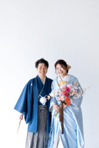 富山のコアラで和装スタジオフォトウェディングを行なっている新郎新婦がブーケを持って微笑んでいる