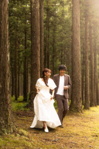 富山のコアラで洋装フォトウェディングを行なった新郎新婦が笑い合って走っている様子