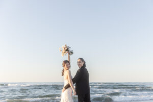 富山のコアラで洋装フォトウェディングを行なった花嫁がブーケを高く上げて笑っているフォトウェディング