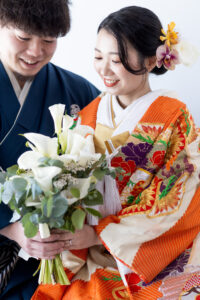 富山のコアラで和装スタジオフォトウェディングを行なっている新郎新婦がブーケを見つめ合っている