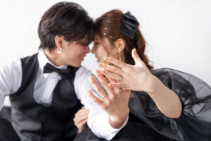 富山のコアラがスタジオでフォトウェディングでブラックドレスを着て撮影している新郎新婦が指輪を見せている様子