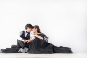 富山のコアラでブラックドレスを着てスタジオで撮影している新郎新婦がおでこを寄せ合っている様子