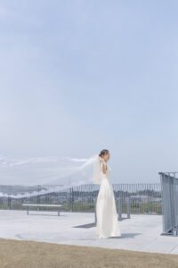 富山のコアラで青空の中で花嫁がベールを広げているフォトウェディング