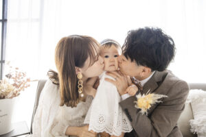 富山のコアラで洋装フォトウェディングを行う新郎新婦が子供にキスをしているフォトウェディング