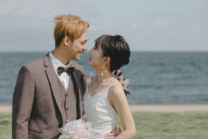 富山のコアラが洋装ロケーションフォトウェディングを行ない新郎新婦が微笑み合っている様子