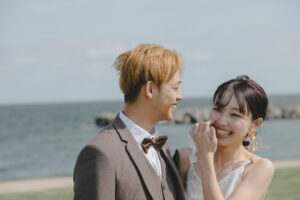 富山のコアラで洋装海フォトウェディングを行なった新郎新婦が笑い合っている様子