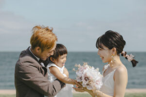 富山のコアラが海ロケーションで洋装フォトウェディングをファミリーで行なった新郎新婦