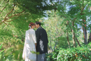 富山のコアラで和装ロケーションフォトウェディングを行なった新郎新婦が花キスをしている様子