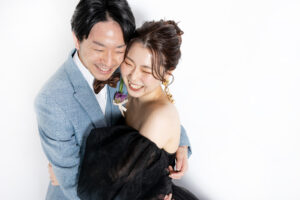 富山のコアラのスタジオでブラックドレスを着た新郎新婦がハグをして笑顔のフォトウェディング