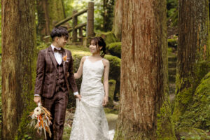 富山のコアラで森林の中で洋装フォトウェディングを行なった新郎新婦が見つめ合っている様子