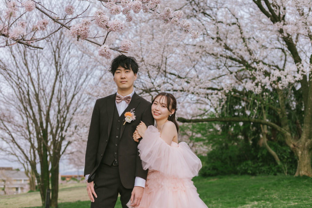 富山のロケーションフォトウェディングで桜と一緒に撮影したカラードレスの新郎新婦