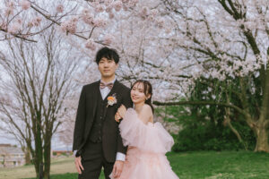 富山のロケーションフォトウェディングで桜と一緒に撮影したカラードレスの新郎新婦