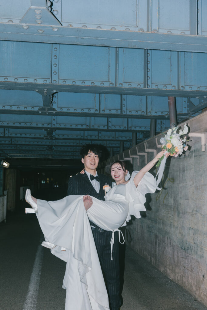 富山の高架線の下でナイトフォトウェディングを楽しむ夫婦