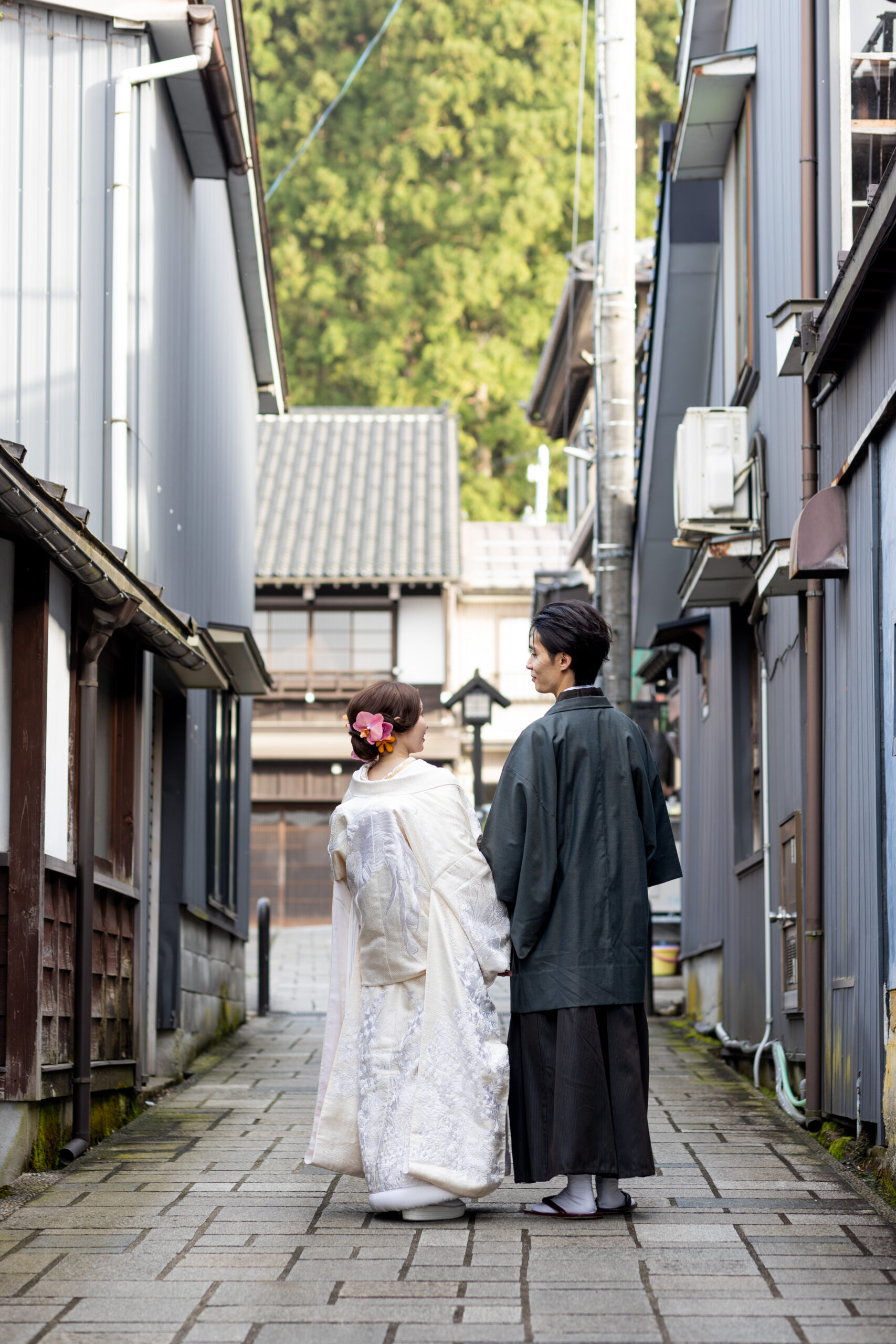 古い木造の町並みにたたずむ和装の花嫁